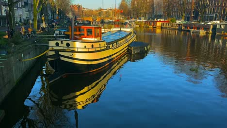 Hausboot-Leuchtet-Idyllisch-Im-Sonnenlicht-Auf-Einem-Holländischen-Kanal-Im-Zentrum-Von-Amsterdam