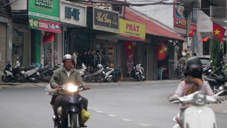 People-in-Masks-Travel-Riding-Motorcycles-in-Downtown-of-Da-Lat-City,-Lam-Dong,-Vietnam