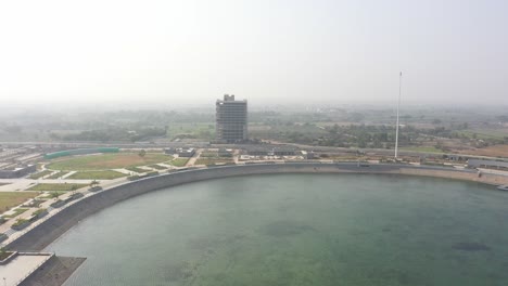 rajkot-atal-lake-drone-view-drone-camera-is-moving-forward-there-is-a-big-building-work-going-on-and-a-big-garden-is-visible-all-around,-Rajkot-New-Race-Course,-Atal-Sarovar