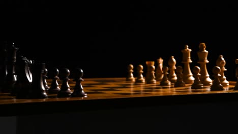 Cinematic-shot-of-chess-pieces-on-a-chessboard,-the-background-is-black,-and-the-light-source-is-coming-from-the-right