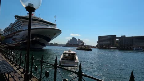 Cruise-ship-docked-at-Sydney-Harbour-with-Opera-House-in-background,-sunny-day
