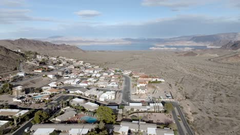 Neighborhood-in-Boulder-City,-Nevada-with-Lake-Mead-in-the-distance-and-drone-video-moving-in