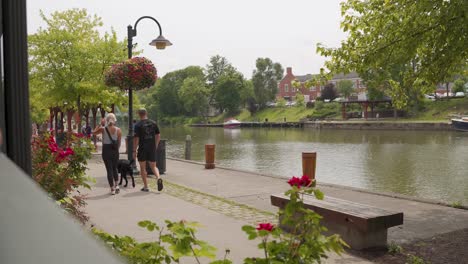 Paar-Mit-Hund-Im-Gespräch-Beim-Spaziergang-Auf-Dem-Treidelpfad-Des-Eriekanals-In-Pittsford,-New-York,-USA