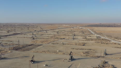 Drone-flight-forward-over-oil-pumps-in-Central-California,-USA