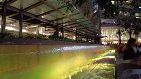 Nachtansicht-Der-Mini-Wasserfälle-Vor-Dem-Einkaufszentrum-Am-Fuße-Der-Petronas-Twin-Towers,-Ein-Ikonisches-Symbol-Für-Malaysias-Wohlstand-Und-Die-Boomende-Ölwirtschaft-Des-Landes