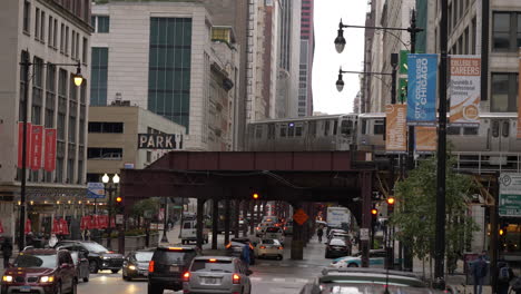 Tren-Chicago-Cta-Loop-Viajando-En-Ferrocarril-Elevado-Con-Tráfico-Matutino-Debajo-En-Una-Mañana-Nublada-En-El-Centro,-Cámara-Lenta-De-4k