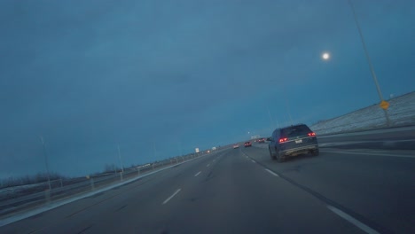 Highway-car-tilted-view-with-full-moon-at-evening-in-Calgary,-Alberta,-Canada