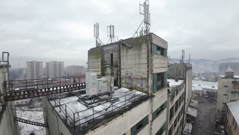 Close-up,-rooftop-of-abandoned-industrial-building,-east-european-town-on-a-cloudy,-moody-day
