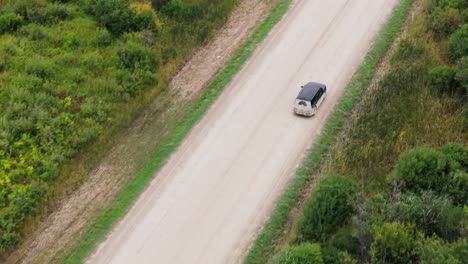 Drone-shot---Following-a-Minivan-Driving-on-an-dirt-road