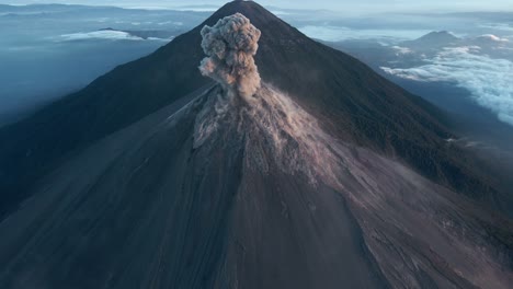 Imagen-Aérea-Cinematográfica-De-La-Erupción-Masiva-Del-Volcán-De-Fuego-Con-Una-Columna-De-Ceniza-Que-Aumenta-Dramáticamente-Y-El-Volcán-Acatenango-Con-Campamentos-Visibles-Al-Fondo.