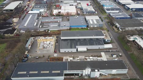 Aerial-of-industrial-site-with-photovoltaic-solar-panels-on-top-of-company-rooftops