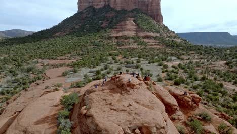 Buttes-in-Sedona,-Arizona-with-people-on-top-and-drone-video-moving-in-a-circle