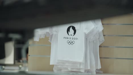 Primer-Plano-De-Una-Camiseta-Estampada-De-Los-Juegos-Olímpicos-De-París-En-Una-Exhibición-En-Un-Centro-Comercial-En-Francia