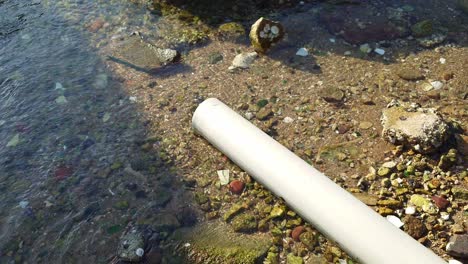 Vista-De-Perfil-De-Una-Tubería-Que-Excreta-Desechos-En-El-Agua-Durante-El-Día-En-Lei-Yue-Mun,-Hong-Kong