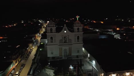 Saint-Mary-of-Guadalupe's-night-aerial,-capturing-the-illuminated-facade-and-grand-entry-in-Tecalitlan