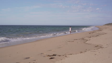 Joven-Caminando-Por-La-Playa-En-Bunbury,-Australia---Plano-Amplio
