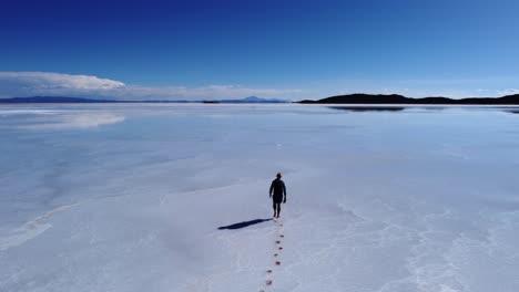 Lone-man-walking-leaves-footprints-in-Uyuni-Salt-flat-lake-in-Bolivia