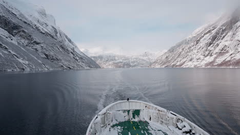 Vídeo-En-Primera-Persona-De-Un-Viaje-En-Ferry-A-Través-Del-Fiordo-De-Geiranger-En-Invierno,-Que-Presenta-Impresionantes-Vistas-De-Montañas-Cubiertas-De-Nieve,-Un-Cielo-Brillante-Y-Reflejos-En-El-Fiordo.