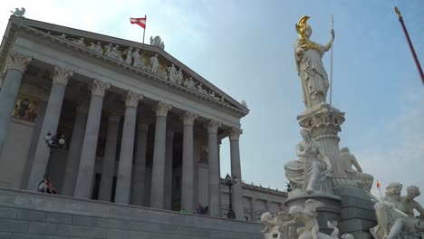 Frontal-Facade-of-Austrian-Parliament-with-Austrian-Flags-Waving-in-Wind