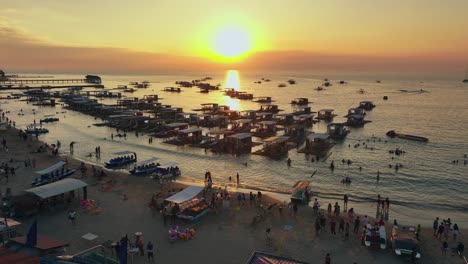 Aerial-approaching-shot-of-many-tourist-and-native-people-at-sandy-beach-of-Matangbukay,-Philippines