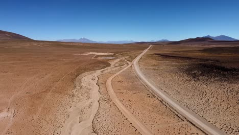 Dirt-road-traverses-vast-desert-altiplano-in-remote-Bolivian-mountains