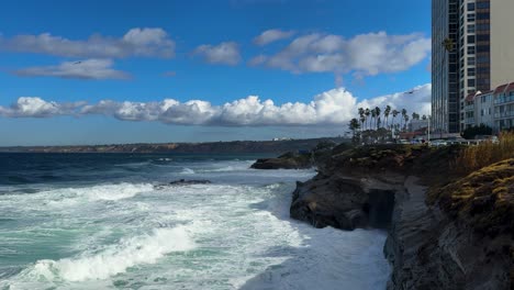 King-tide-at-La-Jolla-Cove-skyline-view-over-waves-crashing-on-clliffs-birds-flying-by.
