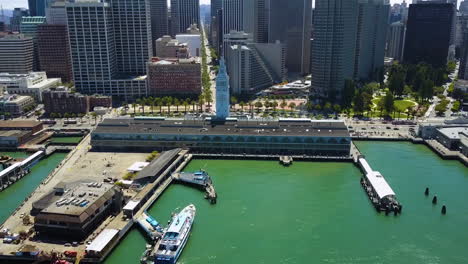 Aerial-view-approaching-the-Ferry-Building,-in-sunny-Embarcadero,-San-Francisco