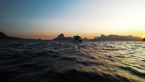 A-yacht-cruising-the-seas-of-Brazil-at-sunset,-Rio