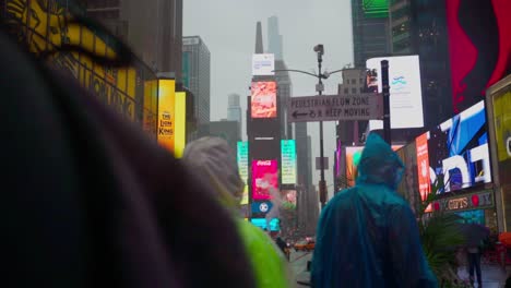 Geschäftigen-Abend-Pendlerverkehr-Im-Strömenden-Regen-In-Der-Grell-LED-Beleuchteten-Times-Square-District