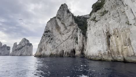 Moving-reveal-of-cliff-faces-off-the-coast-of-Capri,-Italy