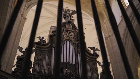 Toma-Panorámica-Del-Interior-De-Una-Iglesia-Gótica-Con-Una-Estatua-En-ángulo-Y-Un-Gran-órgano