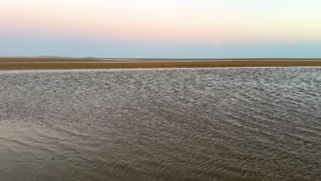 Weite-Luftaufnahme-Des-Flugs-über-Das-Meer-Am-Sandstrand-Im-Arabischen-Golf,-Wundervolle-Natur,-Malerische-Skyline-Bei-Sonnenuntergang,-Farbenfrohe-Dämmerung-Am-Horizont,-Rosa-violette-Farbe,-Venusgürtel,-Erdschatten-Auf-Dem-Ozean