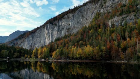Der-Ruhige-See-Spiegelt-Das-Leuchtende-Herbstlaub-Wider,-Das-Sonnenlicht-Fällt-Durch-Die-Bäume-Und-Erzeugt-Ein-Faszinierendes-Kaleidoskop-Aus-Farben