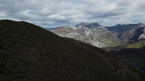 Reversing-around-ridge-overlooking-a-distant-landscape-filled-with-mountain-peaks