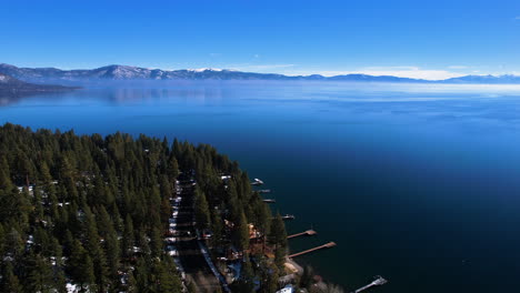 Aerial-View-of-Lake-Tahoe-on-Sunny-Winter-Day,-Forest,-Coastal-Road-and-Blue-Water,-Nevada-California-Border-USA