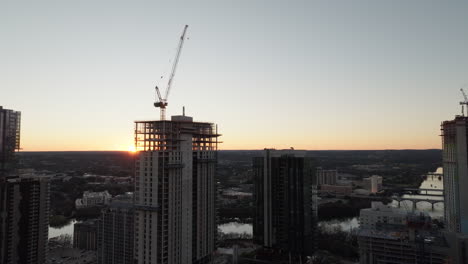 Aerial-shot-of-cranes-in-construction-site-building-high-riser-apartments-and-offices