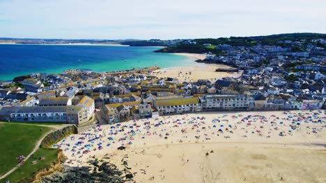 Scenic-Town-of-St-Ives-in-Cornwall-with-Panning-Drone-Shot-with-Porthmeor-Beach-and-Tourists-Sunbathing