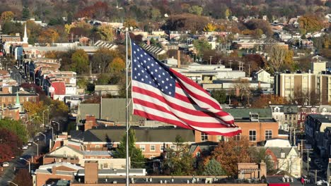 Amerikanische-Flagge-Weht-über-Urbanem-Stadtbild-Mit-Herbstlaub