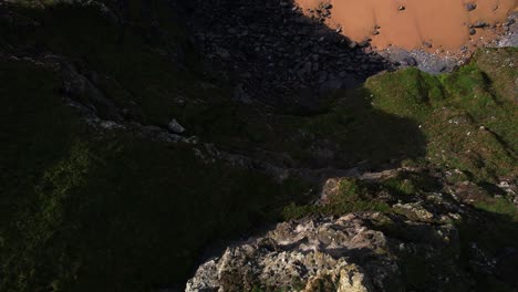 Top-Down-View-Over-Bedruthan-Steps-in-Cornwall-with-Rocky-Cliffs-and-Golden-Sands