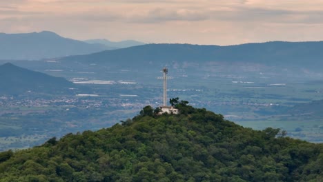 Panorama-De-Cerca-Del-Monumento-A-La-Cruz-En-Tecalitlán,-Con-Vista-A-Pastos-Verdes-Y-Un-Paisaje-Montañoso.