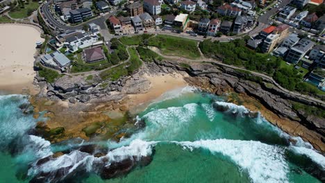 Turquoise-Seascape-And-Architecture,-Tamarama-Beach,-Eastern-Suburbs,-Sydney,-Australia---Aerial-Drone-Shot