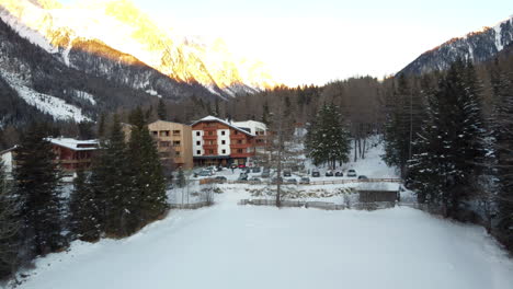 Los-Edificios-Del-Hotel-Se-Encuentran-En-Medio-Del-Prístino-Paisaje-Alpino,-Su-Encanto-Acentuado-Por-La-Nieve-Blanca-Y-Pura,-Ofreciendo-Un-Refugio-Acogedor-En-El-Paraíso-Invernal-De-Los-Alpes.