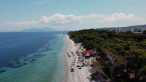 Luftaufnahme-Des-Weißen-Sandstrandes-Und-Des-Türkisfarbenen-Meeres-In-Einem-Touristenort-In-Xylokastro,-Griechenland