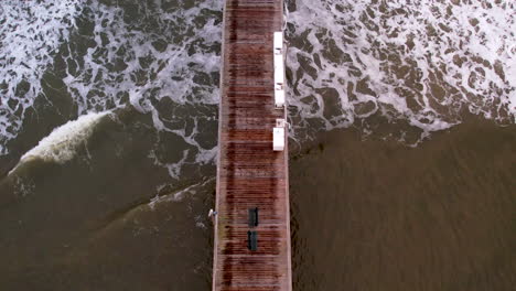 Fishing-pier-and-ocean-aerial-straight-down