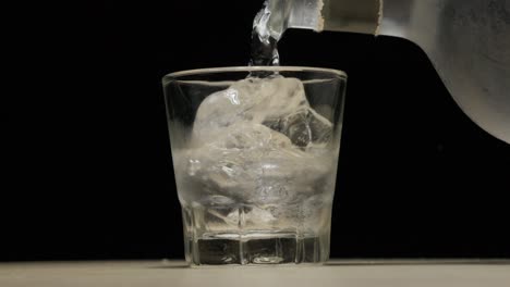 Pouring-alcohol-with-ice-on-shot-glass