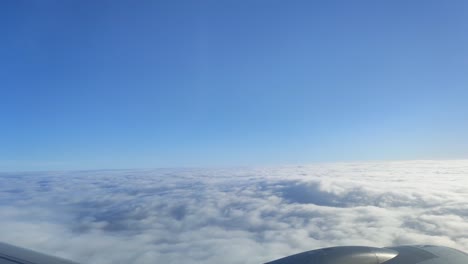 Luftaufnahme-Der-Wolkenlandschaft-Im-Morgengrauen-Durch-Das-Flugzeugfenster