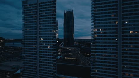 Aerial-drone-view-of-modern-office-building-and-apartments-at-dusk-or-night