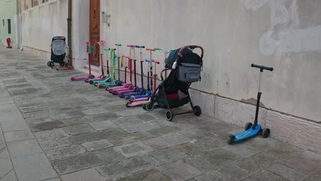 Scooters-and-Stroller-Lined-in-Venice-Alley,-Italy