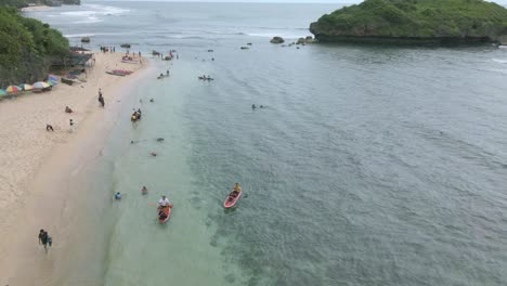 Aerial-view-of-people's-area-swimming,-play-and-kayak-on-the-white-tropical-beach