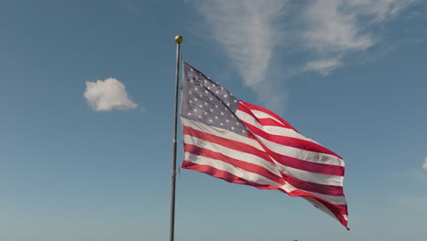 Toma-Patriótica-En-Cámara-Lenta-De-Una-Bandera-Estadounidense-Ondeando-En-El-Viento-Contra-El-Cielo-Azul